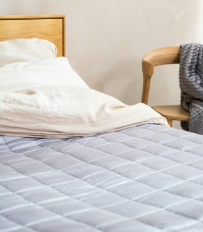 a bed with a white comforter and a wooden headboard